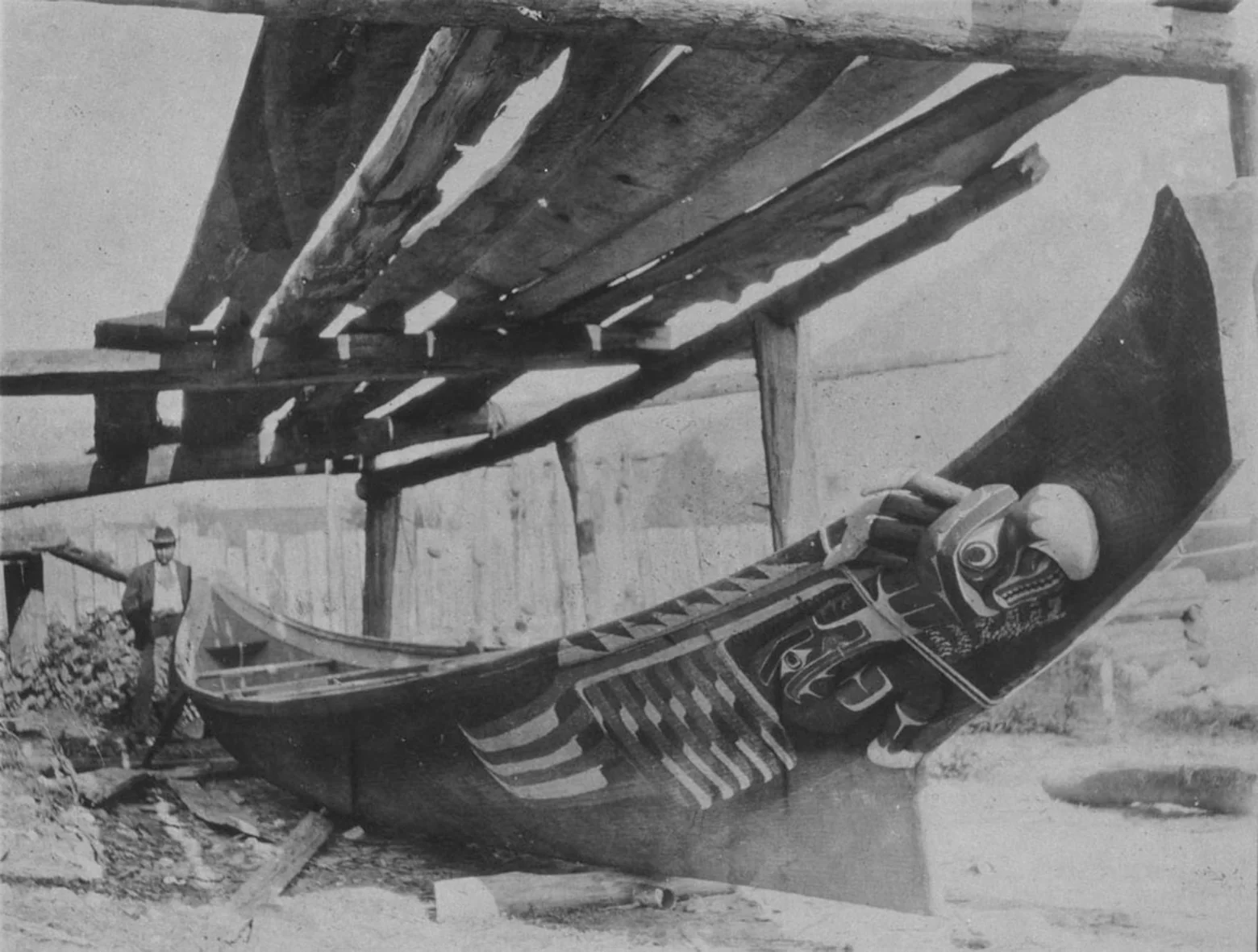 A large Northwest Coast war canoe with a carved and painted formline prow.